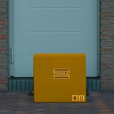 Yellow package lying on a doorstep after being purchased online using a buy now, pay later program
