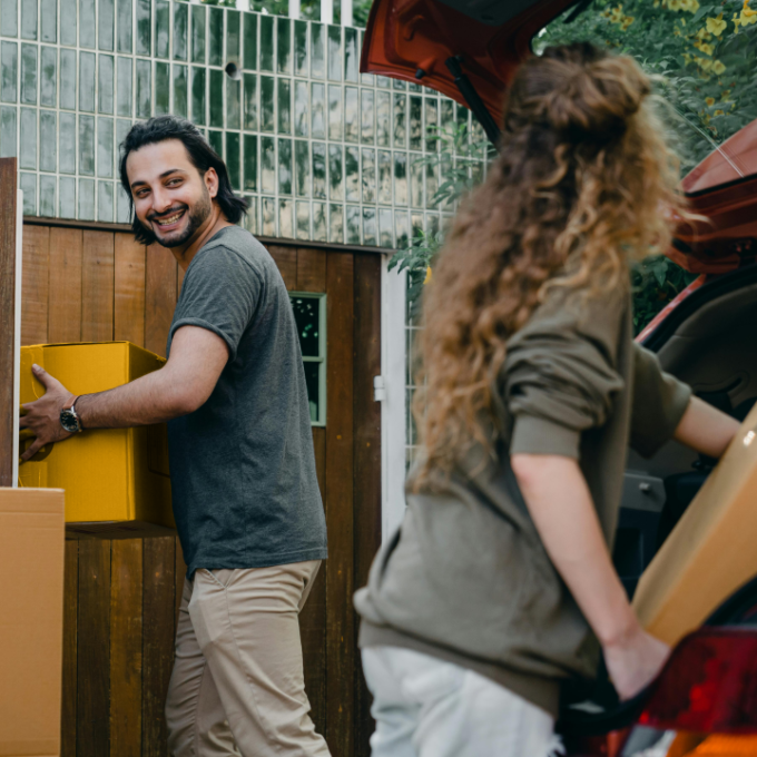 Man and woman unpacking moving boxes into new home