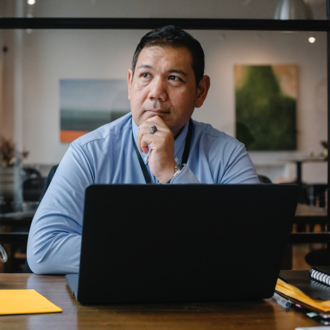 Man seated at a desk contemplating filing personal bankruptcy