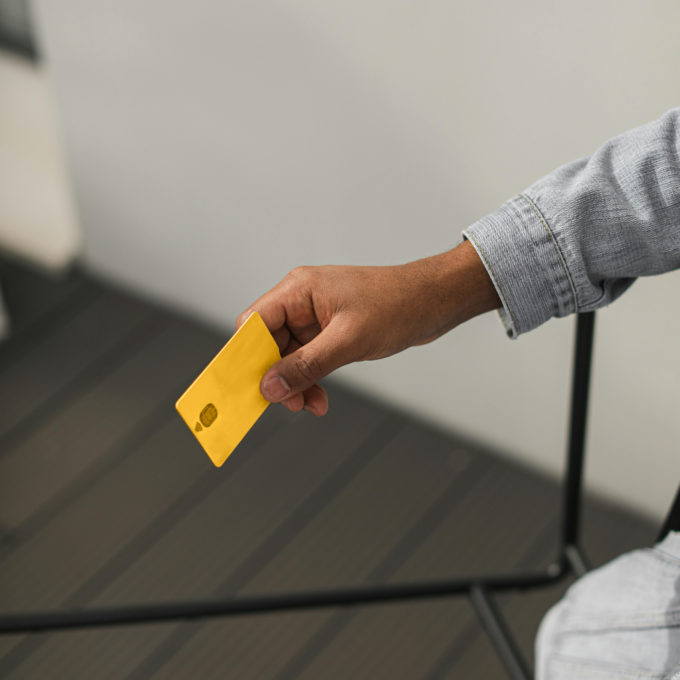 Personne détenant une carte jaune cherchant des solutions pour gérer un solde de carte de crédit qu&#039;elle ne peut pas rembourser