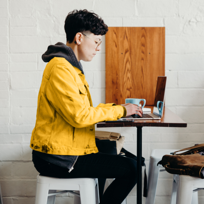 Self employed person seated at a table using a laptop doing taxes