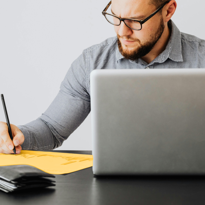 Man seated at a desk contemplating filing a consumer proposal