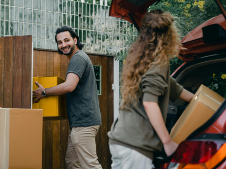Man and woman unpacking moving boxes into new home