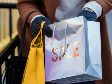 Person holding shopping bags after splurging on a sale