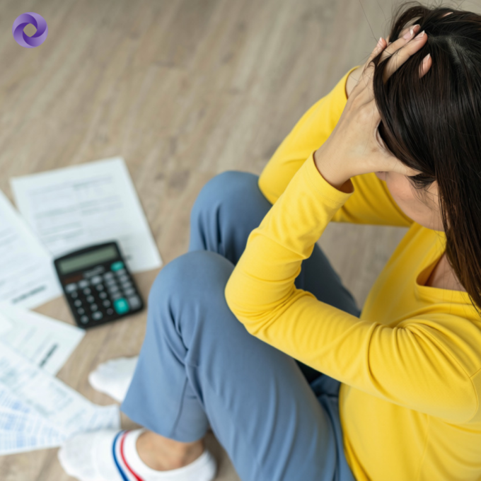 A woman sitting with papers and a calculator in front of her