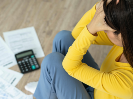 A woman sitting with papers and a calculator in front of her