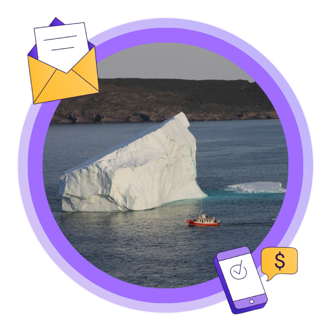Image of a large iceberg and small boat in the water, taken in Newfoundland